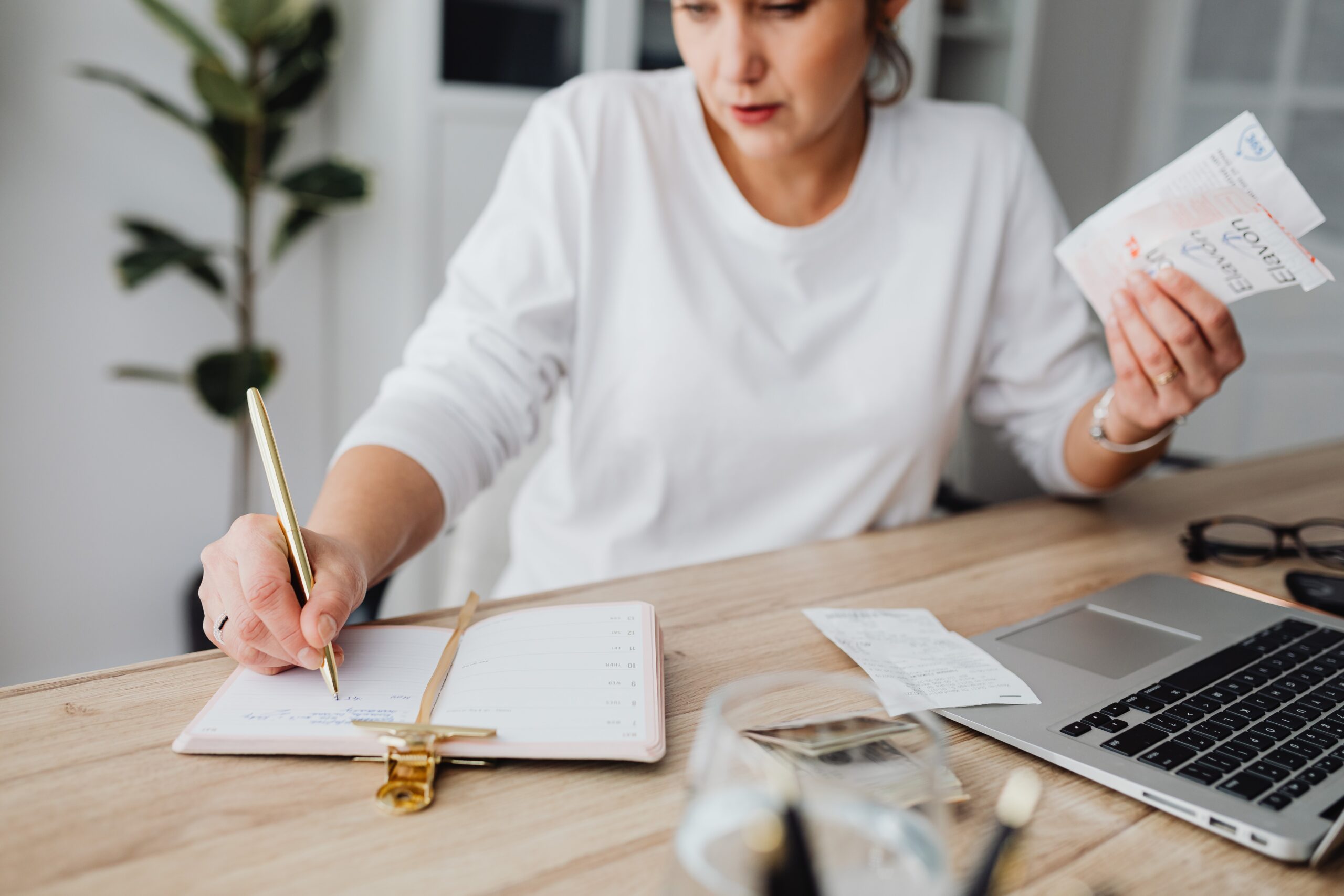 superannuation for women holding bills and writing on paper