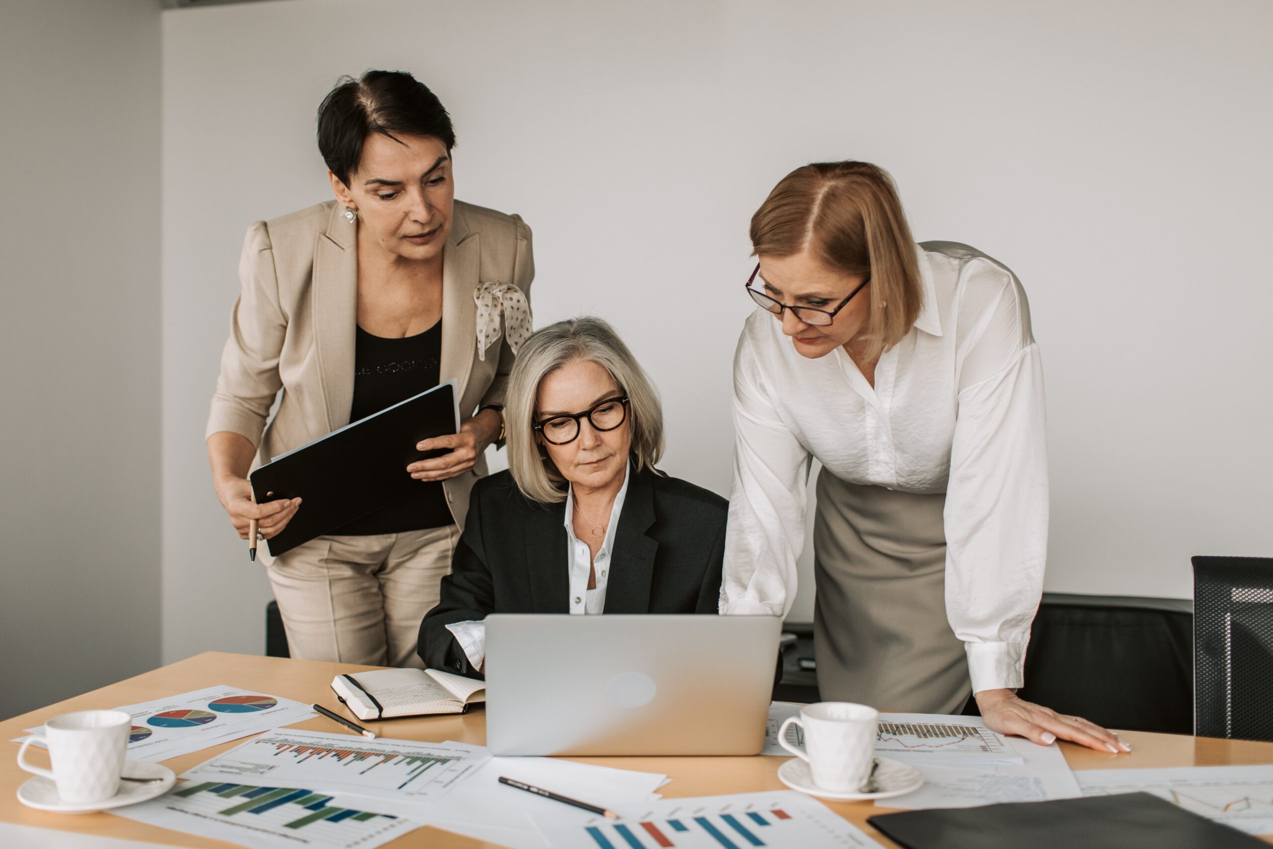 Three women discussing retirement planning in front of a laptop